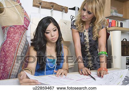 Female fashion designers working at desk View Large Photo Image Stock Photo - Female fashion designers working at desk. Fotosearch