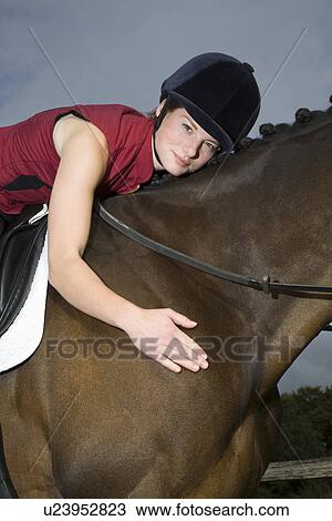 Female horseback rider hugging horse View Large Photo Image Stock Image - Female horseback rider hugging horse. Fotosearch