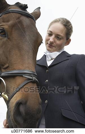 Stock Photograph - Female horseback rider with horse outdoors. Fotosearch