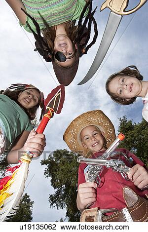 Stock Image - Four children (7-12) wearing costumes. Fotosearch