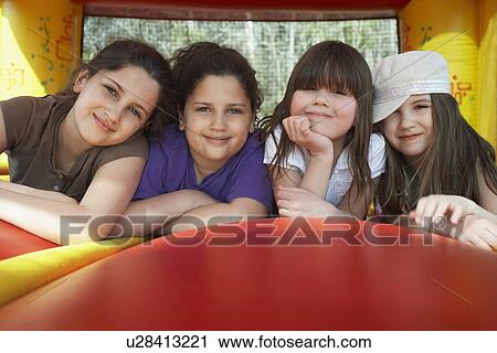 Four girls (7-12) lying in row in bouncy castle portrait View Large Photo Image Stock Image - Four girls (7-12) lying in row in bouncy castle portrait. Fotosearch