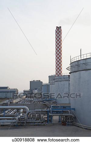 Fuel depot at power station with smokestack in background View Large Photo Image Stock Photo - Fuel depot at power station with smokestack in background. Fotosearch