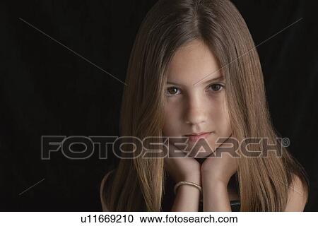 Stock Image - Girl (10-12) on black background portrait. Fotosearch