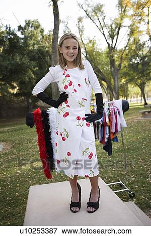 Stock Photo - Girl (10-12) posing on catwalk in park. Fotosearch