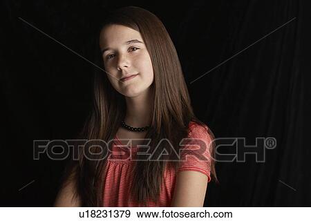 Stock Photo - Girl (13-15) on black background portrait. Fotosearch