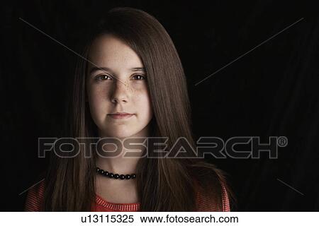 Stock Photography - Girl (13-15) on black background portrait. Fotosearch