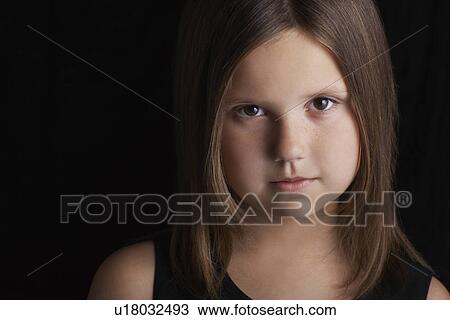 Stock Image - Girl (5-6) on black background portrait close up. Fotosearch