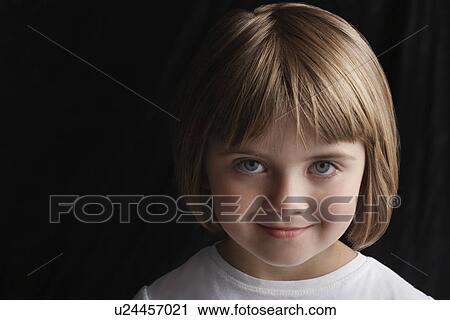 Stock Image - Girl (5-6) on black background portrait close-up. Fotosearch