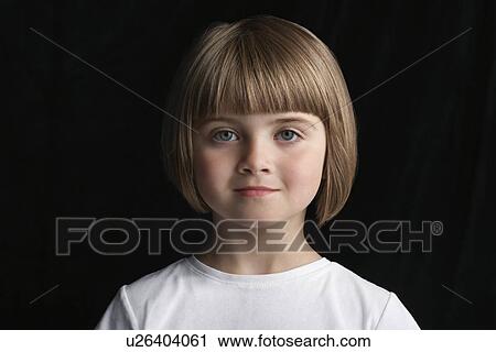 Stock Image - Girl (5-6) on black background portrait close-up. Fotosearch