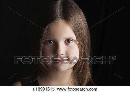 Stock Photography - Girl (7-9) on black background portrait. Fotosearch