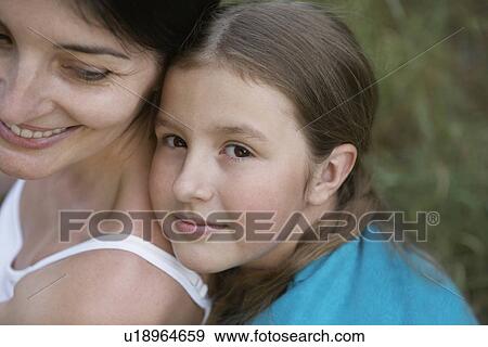 Girl embracing her mother close-up View Large Photo Image Stock Photo - Girl embracing her mother close-up. Fotosearch
