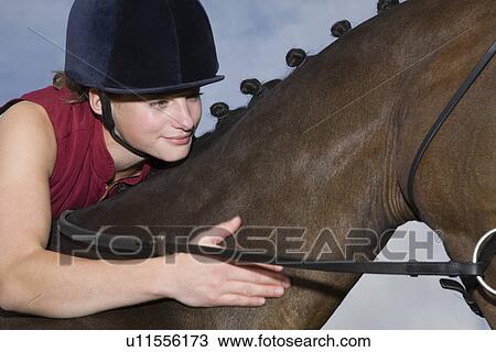 Stock Image - Girl hugging horse close-up. Fotosearch