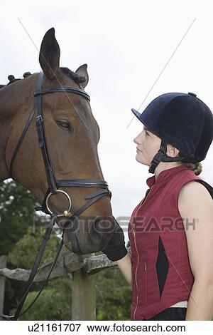Girl in riding hat holding horse View Large Photo Image Stock Photo - Girl in riding hat holding horse. Fotosearch