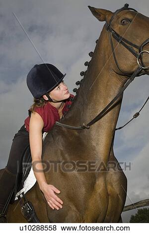 Stock Photo - Girl on horseback low angle view. Fotosearch