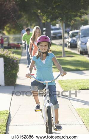 Stock Photograph - Girl riding bicycle. Fotosearch