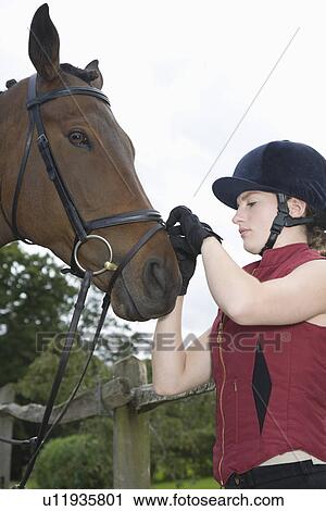 Girl tightening horse's bridle View Large Photo Image Stock Image - Girl tightening horse's bridle. Fotosearch
