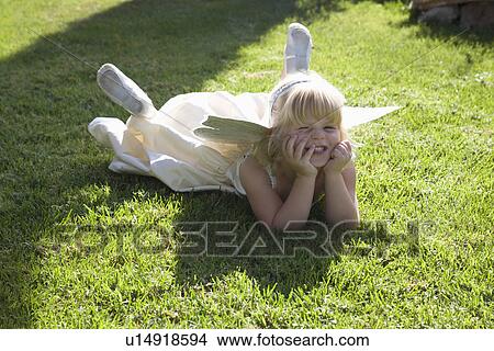 Girl with head in hands lying on grass View Large Photo Image Picture - Girl with head in hands lying on grass . Fotosearch
