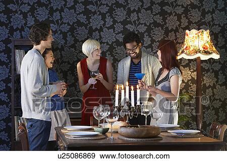 Group of people laughing standing by dining table View Large Photo Image Stock Photo - Group of people laughing standing by dining table. Fotosearch