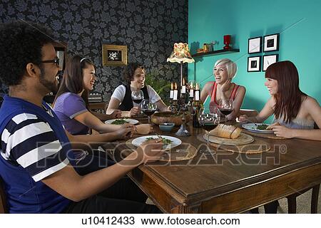 Group of people sitting at dining table View Large Photo Image Stock Image - Group of people sitting at dining table. Fotosearch