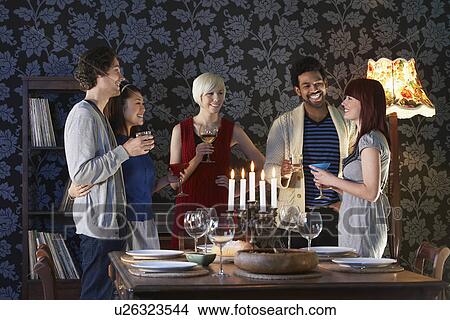 Picture - Group of people smiling standing by dining table. Fotosearch
