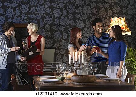 Group of people smiling standing by dining table View Large Photo Image Stock Image - Group of people smiling standing by dining table. Fotosearch