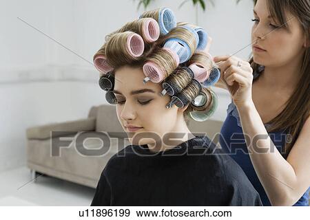 Stock Photo - Hairstylist Rolling Hair of Model. Fotosearch
