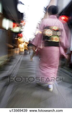 Stock Photo - Japan Kyoto Pontocho-dori Woman wearing kimono walking on narrow street motion blur. Fotosearch