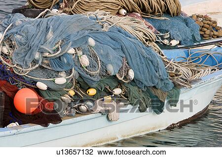 Stock Image - Kalba UAE Fishing nets piled high on boat in Kalbar Fujairah. Fotosearch