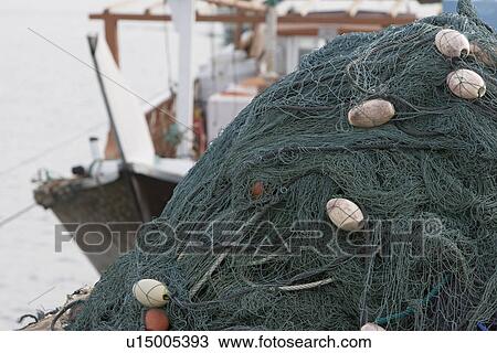 Stock Image - Kalba UAE Fishing nets piled high on boat in Kalbar Fujairah. Fotosearch