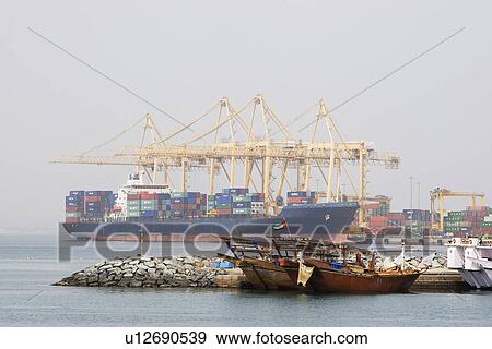 Khor Fakkan UAE Large cargo ships docked to load and unload goods at Khor Fakkport View Large Photo Image Stock Photo - Khor Fakkan UAE Large cargo ships docked to load and unload goods at Khor Fakkport. Fotosearch
