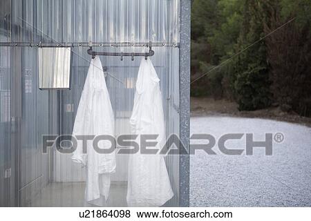 Stock Photo - Lab coats hanging in plastic change room. Fotosearch