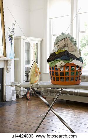 Stock Image - Laundry basket on ironing board. Fotosearch