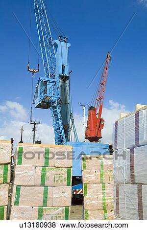 Stock Photo - Limassol Cyprus. Cranes loading a freighter with cargo on quayside. Fotosearch