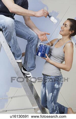 Man on ladder trying to paint woman View Large Photo Image Stock Image - Man on ladder trying to paint woman. Fotosearch