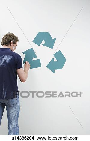 Picture - Man painting recycling sign on wall. Fotosearch