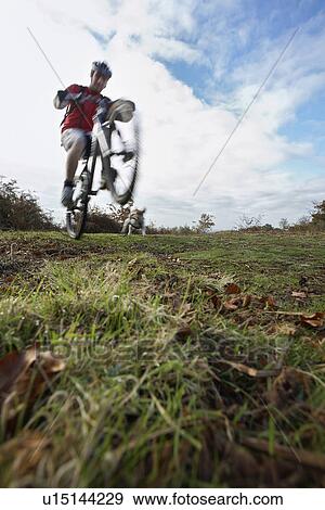Man performing wheeley on mountain bike in countryside View Large Photo Image Stock Photo - Man performing wheeley on mountain bike in countryside. Fotosearch