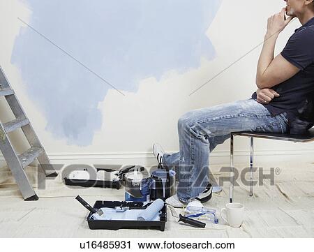 Man resting while painting wall low section View Large Photo Image Stock Image - Man resting while painting wall low section. Fotosearch