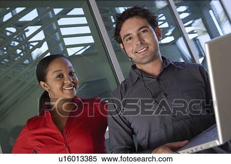 Man Using Laptop with Female Colleague View Large Photo Image Stock Photography - Man Using Laptop with Female Colleague. Fotosearch