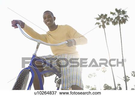 Stock Photo - Man with bike on beach. Fotosearch
