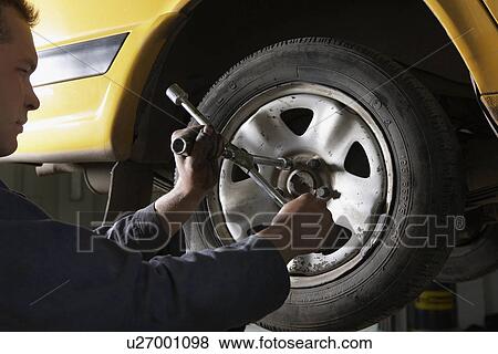 Stock Photo - Mechanic Working on Tire. Fotosearch