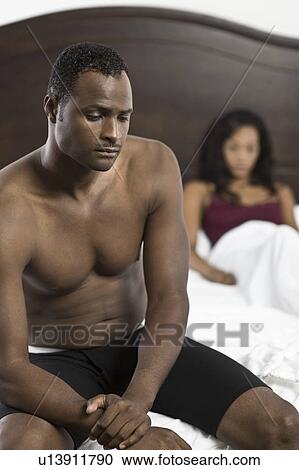 Stock Image - Mid adult couple in bedroom. Fotosearch