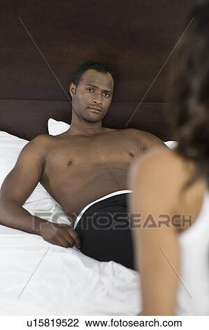 Stock Image - Mid adult couple in bedroom. Fotosearch