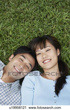 Mid adult couple lying on grass portrait elevated view View Large Photo Image Stock Image - Mid adult couple lying on grass portrait elevated view. Fotosearch