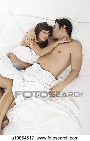 Stock Photo - Mid adult couple sleeping. Fotosearch