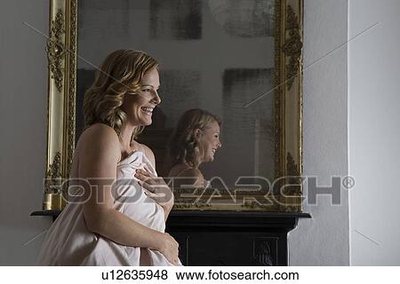 Mid adult woman getting up from bed View Large Photo Image Stock Photo - Mid adult woman getting up from bed. Fotosearch