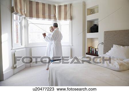 Stock Image - Middle-aged couple dancing in bedroom. Fotosearch