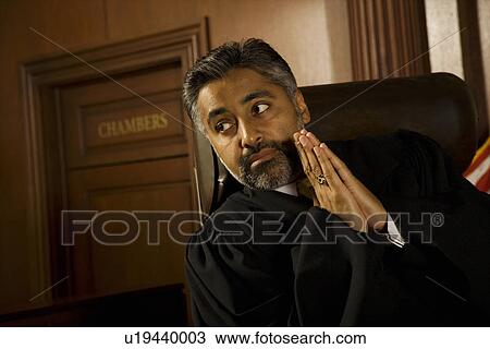 Stock Image - Middle-aged judge in a courtroom. Fotosearch