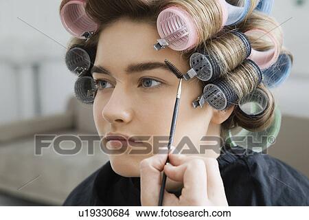 Picture - Model in Hair Curlers Having Makeup Applied. Fotosearch