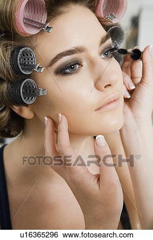 Stock Photograph - Model in Hair Curlers Having Makeup Applied. Fotosearch