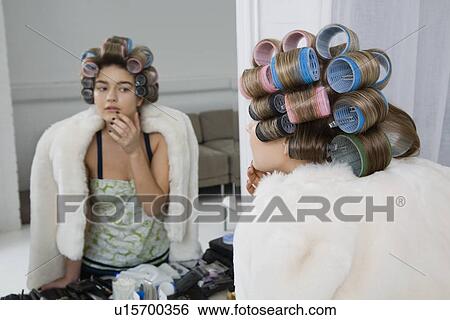 Stock Photograph - Model in Hair Curlers Looking at Reflection. Fotosearch